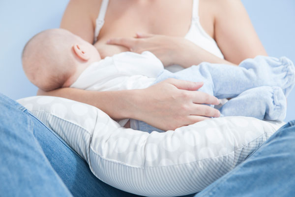 Support baby weight over pillows during breastfeeding